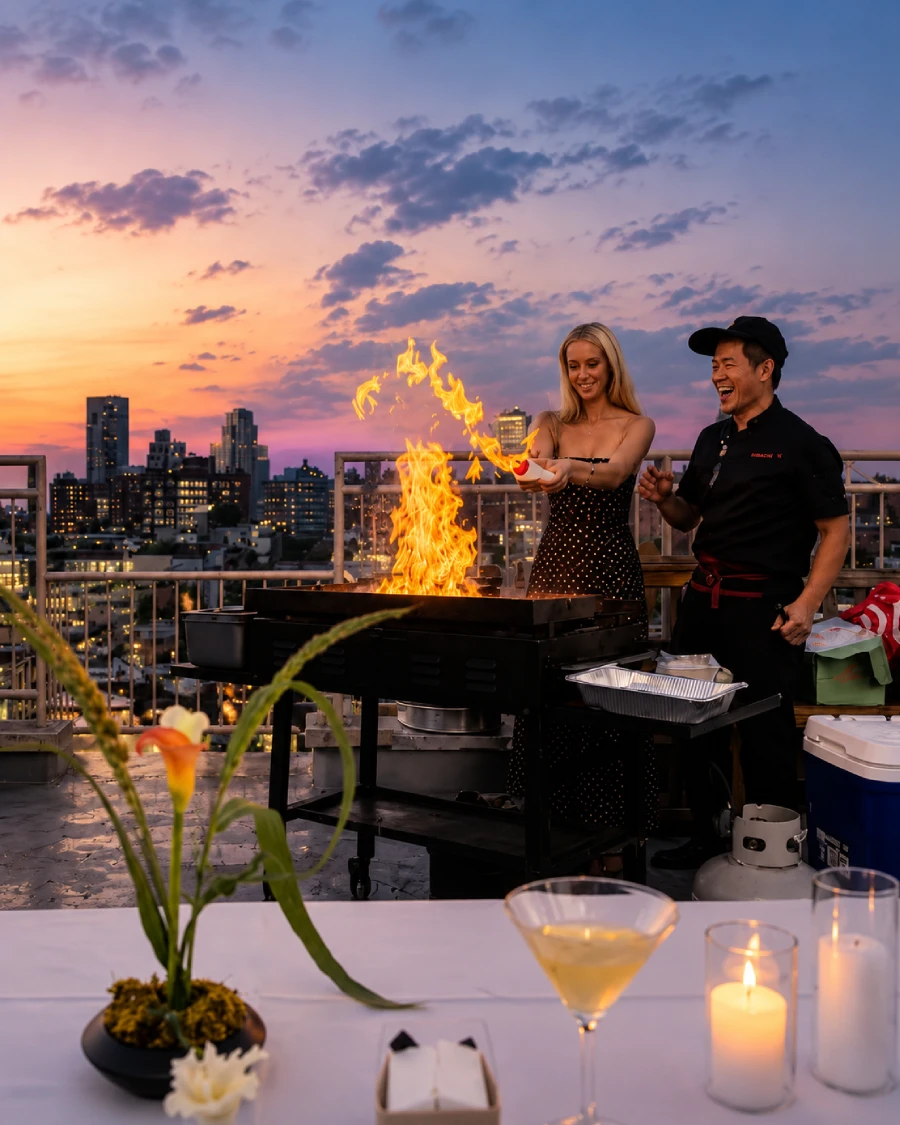 Private hibachi chef interacting with guests on a rooftop in Baltimore Metro