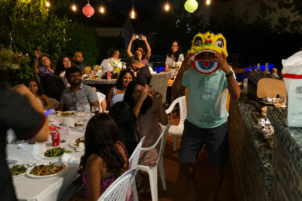 Guests enjoying playful lion dance entertainment during an outdoor hibachi party