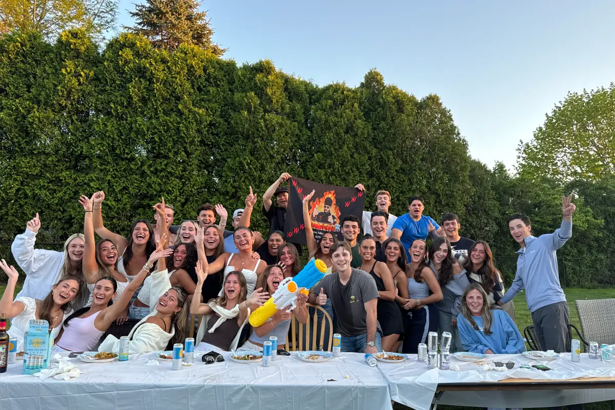 Large group of guests celebrating an outdoor hibachi party with food and dining tables