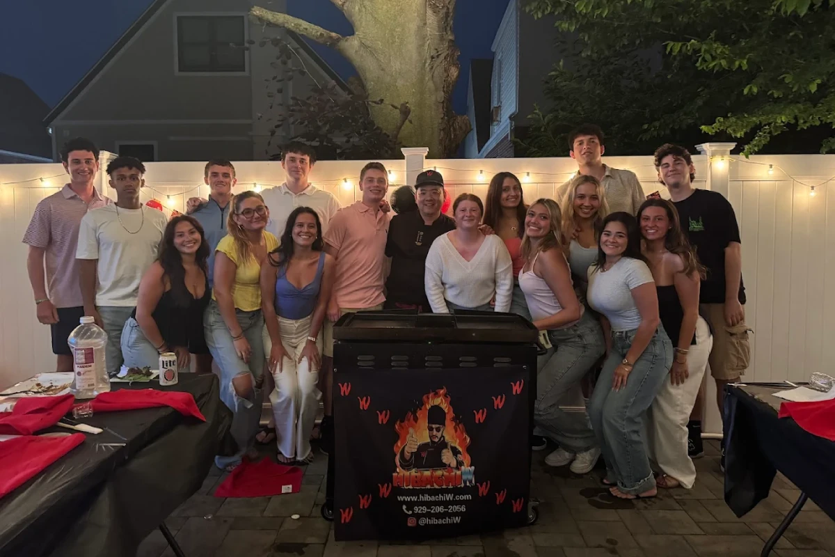 Guests enjoying a private hibachi at home group dinner in a backyard setting